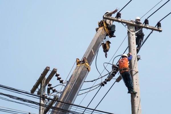 foco-seletivo-de-eletricistas-estao-fixando-a-linha-de-transmissao-de-energia-em-um-poste-de-eletricidade.jpg